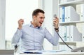 Furious businessman calling on phone in office