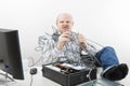 Furious Businessman Holding Tangled Cables Of Computer At Desk