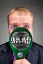 Furious businessman smiling through magnifier Royalty Free Stock Photo