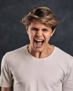 Furious, enraged young man over gray background