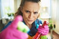 Furious female with cleaning agent threatening with finger