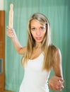 Furious girl swinging arm with rolling-pin
