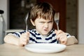 Furious little boy waiting for dinner Royalty Free Stock Photo