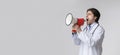 Furious male doctor in uniform shouting at copy space with megaphone Royalty Free Stock Photo