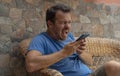 Furious man shouting at his mobile device. Angry aggressive man shouting at his cellphone. Boy with blue shirt screaming at smart Royalty Free Stock Photo