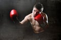 Furious man training boxing on gym with red fighting gloves throwing vicious punch Royalty Free Stock Photo