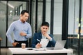 Furious two Asian businesspeople arguing strongly after making a mistake at work in office Royalty Free Stock Photo