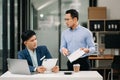 Furious two Asian businesspeople arguing strongly after making a mistake at work in office Royalty Free Stock Photo