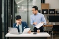 Furious two Asian businesspeople arguing strongly after making a mistake at work in office Royalty Free Stock Photo