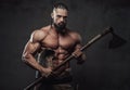 Furious viking posing with naked torso holding axe