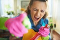 Furious woman with cleaning agent threatening with finger