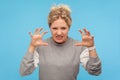 Furious woman with curly hair in sweatshirt standing with raised claws and clenched teeth, experiencing strong anger, irritation Royalty Free Stock Photo