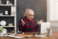 Furious woman working on laptop at office