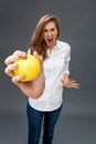 Furious young female model screaming holding an appetizing apple