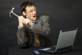 Furious young man breaks hammer computer Royalty Free Stock Photo