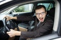 Furious young man is looking at the camera while sitting at his car. He is screaming at someone. His hands are on the steering Royalty Free Stock Photo