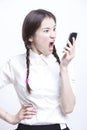 Furious young woman screaming into her cell phone against white background Royalty Free Stock Photo