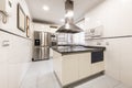 Furnished kitchen with central island with extractor hood, polished black granite countertops and integrated stainless steel Royalty Free Stock Photo