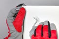 Furniture assembler in red gloves is screwing in a screw with a hex wrench Royalty Free Stock Photo