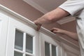 Furniture assembly. A man assembles a kitchen set, attaches stucco molding to the upper cabinets Royalty Free Stock Photo