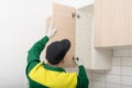 The furniture assembly specialist hangs the fronts on the top cabinet of the kitchen unit