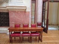 Furniture in the central hall of the Nacional Assembly of Serbia, elegant wooden red chairs and a brown table