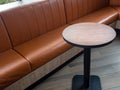 Furniture decoration in cafe retro style. Empty round wood table bar and orange long leather sofa on wood floor Royalty Free Stock Photo