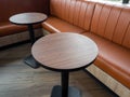 Furniture decoration in cafe retro style. Empty round wood table bars and orange long leather sofa on wood floor Royalty Free Stock Photo