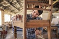 Furniture maker skillfully sanding a chair in his workshop