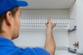 Furniture service worker installing kitchen cabinet dish rack Royalty Free Stock Photo