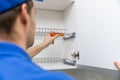 Furniture service worker screwing kitchen cabinet dish rack Royalty Free Stock Photo