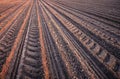 Furrows row pattern in a plowed field prepared for planting crops in spring.