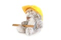 Furry, cuddly, cute little rabbit bunny toy in yellow helmet with hammer on white background, mockup with copy space, toys for Royalty Free Stock Photo