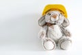 Furry, cuddly, cute little rabbit toy in yellow helmet on white background with copy space Royalty Free Stock Photo