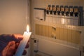 Fuse box with fuses in a distribution box during a power outage lit with white candle holding a man with the word blackout as text Royalty Free Stock Photo