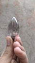 Small sharp glass light bulb in the hand