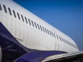 Fuselage of airplane with door and windows. Row of portholes outside the passenger aircraft. Plane on bly sky background Royalty Free Stock Photo