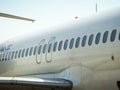 Fuselage of airplane with door and windows. Row of portholes outside the passenger aircraft. Plane on bly sky background