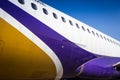 Fuselage of airplane with door and windows. Row of portholes outside the passenger aircraft. Plane on bly sky background Royalty Free Stock Photo