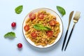 Fusilli - classic italian pasta from durum wheat with chicken meat, tomatoes cherry, basil in tomato sauce in white bowl on blue Royalty Free Stock Photo