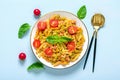 Fusilli - classic italian pasta from durum wheat with chicken meat, tomatoes cherry, basil in tomato sauce in white bowl on blue Royalty Free Stock Photo