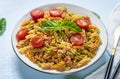 Fusilli - classic italian pasta from durum wheat with chicken meat, tomatoes cherry, basil in tomato sauce in white bowl on blue Royalty Free Stock Photo