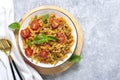 Fusilli - classic italian pasta from durum wheat with chicken meat, tomatoes cherry, basil in tomato sauce in white bowl on gray c Royalty Free Stock Photo