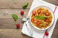 Fusilli - classic italian pasta from durum wheat with chicken meat, tomatoes cherry, basil in tomato sauce in white bowl, napkin, Royalty Free Stock Photo