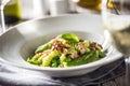 Fusilli pasta with green peas ham walnuts with white wine. italian or mediterranean cuisine