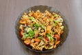 Fusilli pasta with pesto, colorful tomatoes, mushrooms, carrot and basil leaves on dark wooden table. Italian food Royalty Free Stock Photo