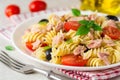 Fusilli pasta salad with tuna, tomatoes, black olives and basil on gray stone background Royalty Free Stock Photo