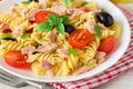 Fusilli pasta salad with tuna, tomatoes, black olives and basil on gray stone background Royalty Free Stock Photo