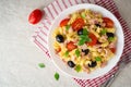 Fusilli pasta salad with tuna, tomatoes, black olives and basil on gray stone background Royalty Free Stock Photo