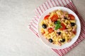 Fusilli pasta salad with tuna, tomatoes, black olives and basil on gray stone background Royalty Free Stock Photo